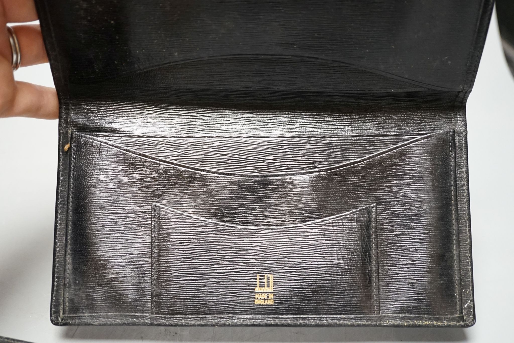 An Alfred Dunhill gold plate mounted leather wallet, 18.9cm, and one other 9ct gold mounted leather wallet initialled J.B.S., 17.9cm.
